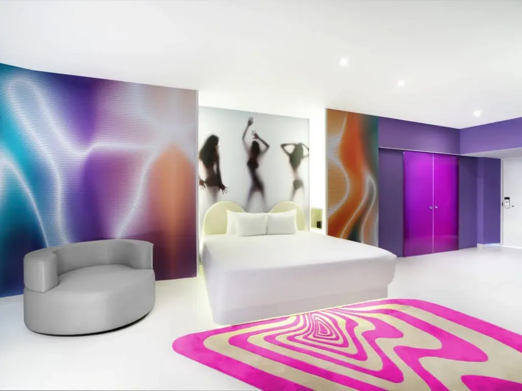 Bash Tower Ocean View room with white bed and vivid pink and purple decor