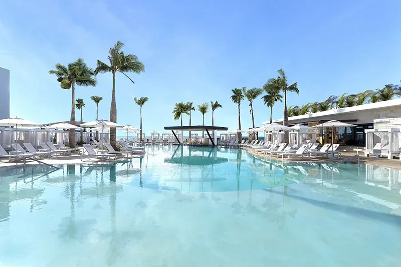 Palm-lined Sensual Pool with in-water loungers and swim-up bar